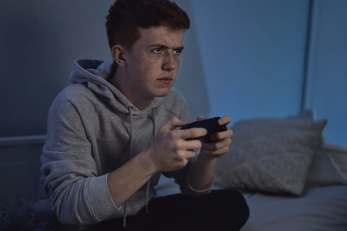 A teenager with a video game addiction playing games late into the night.