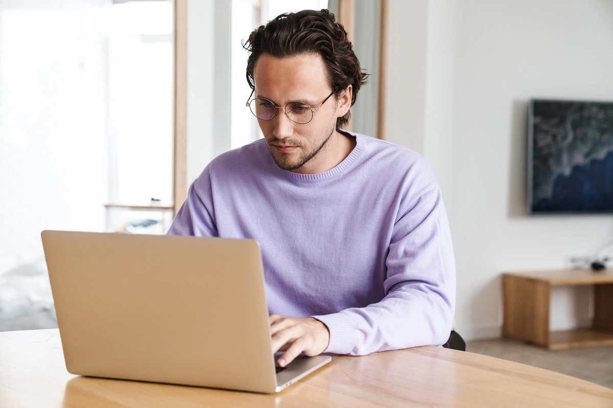 A man on his laptop, searching for detox centers in his area.