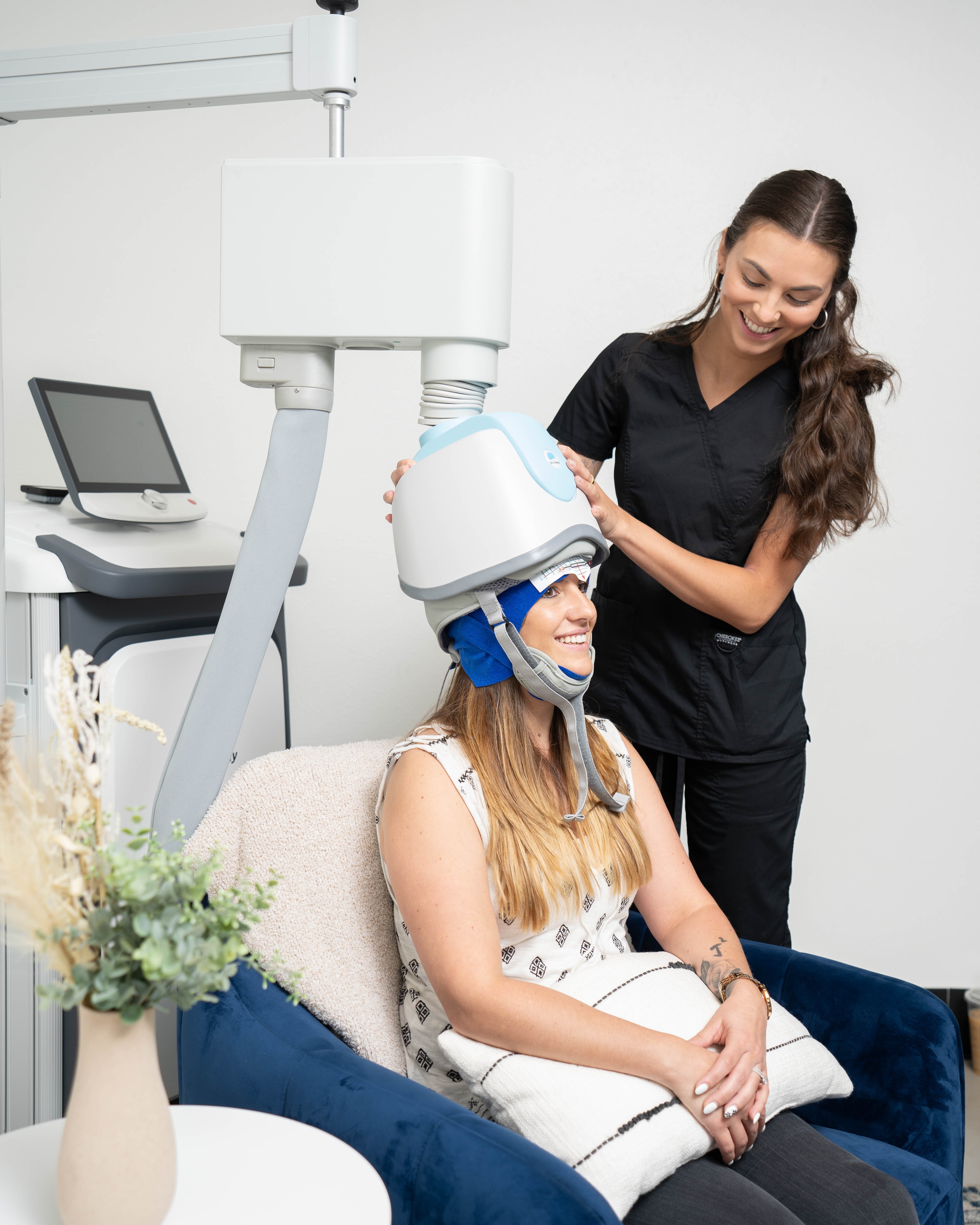 A woman having the TMS helmet placed on her head.