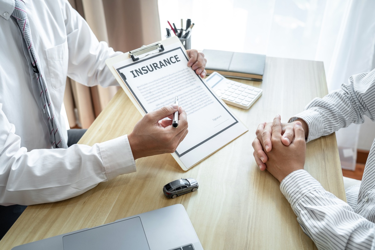 A doctor holds an insurance form in front of a patient who is considering outpatient rehab.