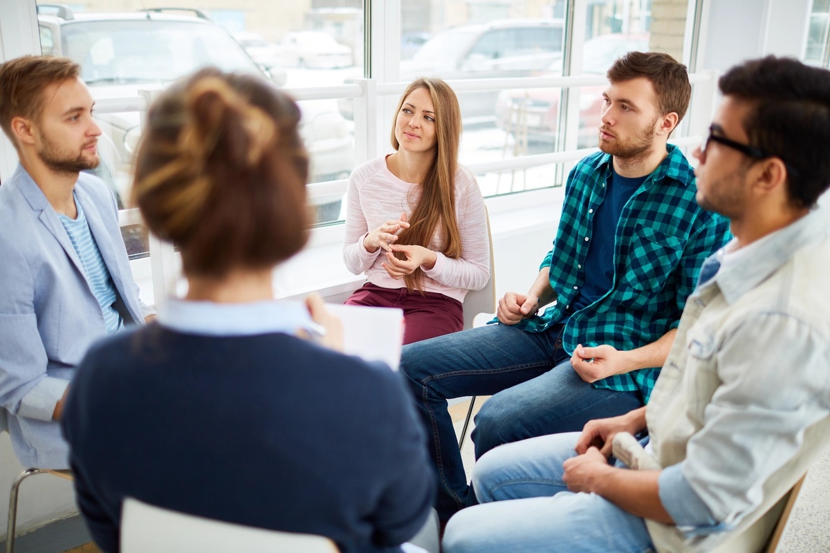 Four people sitting in on a gambler's anonymous support group.