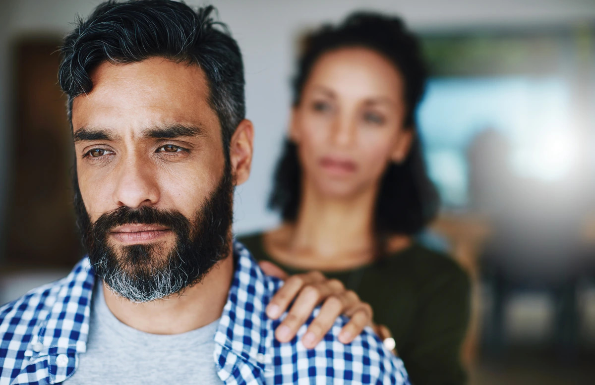 A woman comforting her husband as he struggles with the depressive symptoms of bipolar disorder.