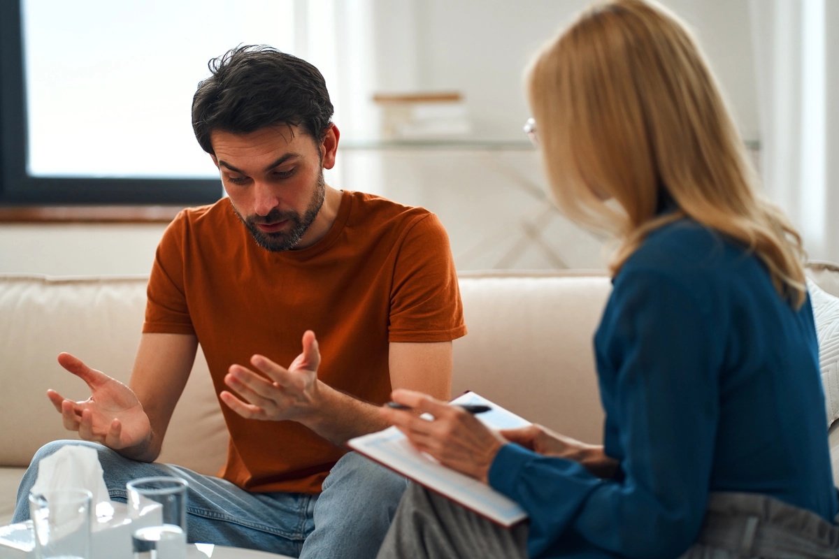 A man in a motivational interviewing session with his counselor, discussing how he can make healthier life changes.