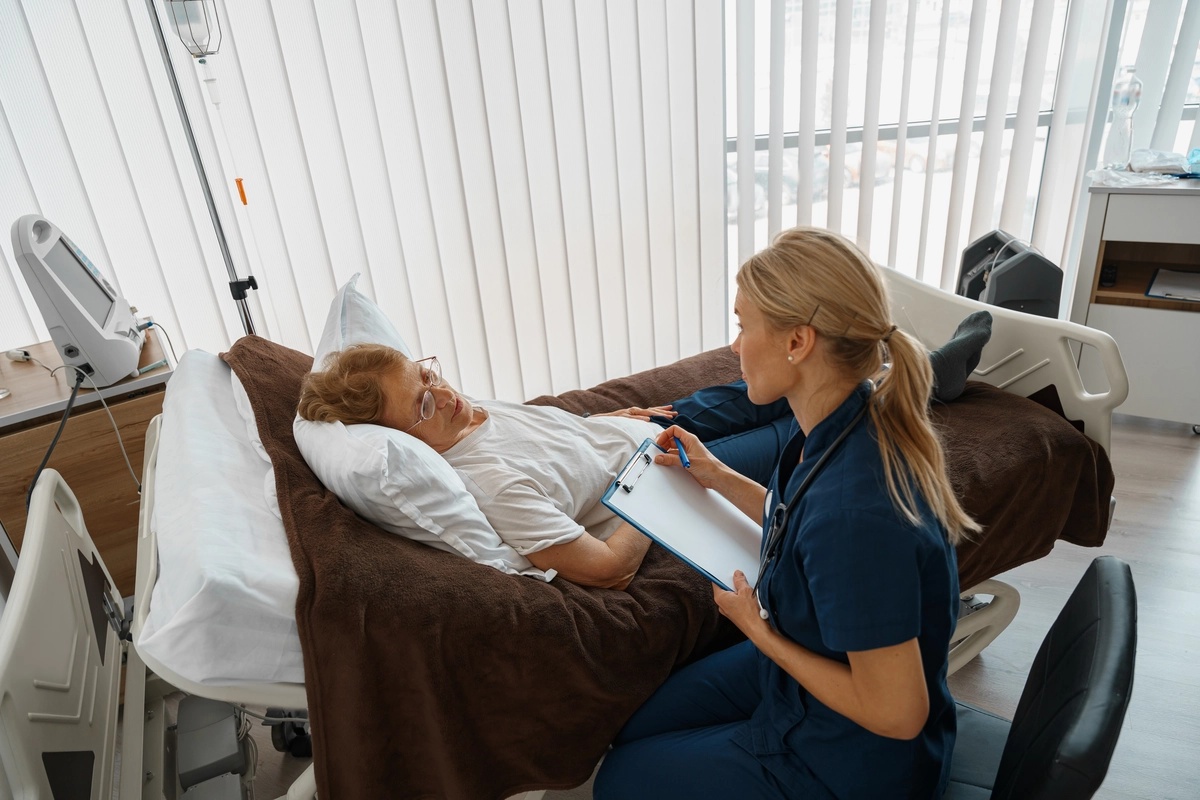 A nurse talking to a man in crisis stabilization on a hospital bed