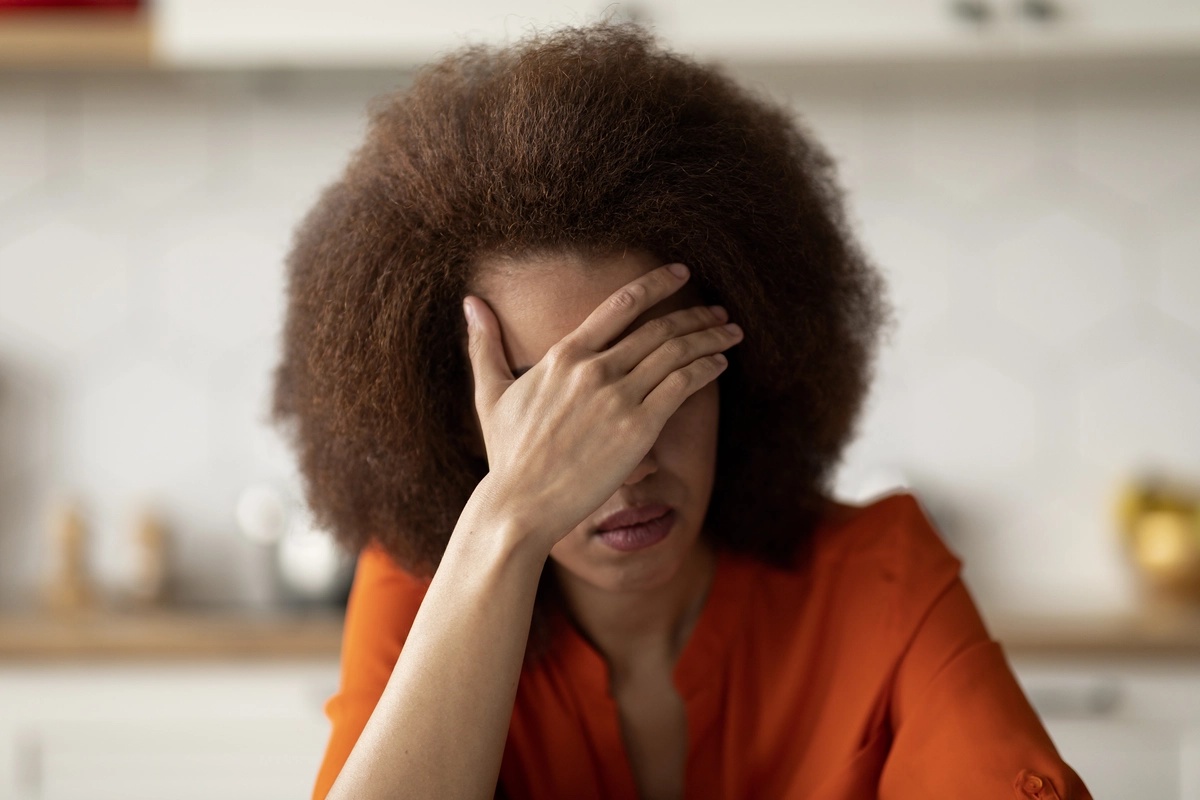 A woman holding her hand to her face.