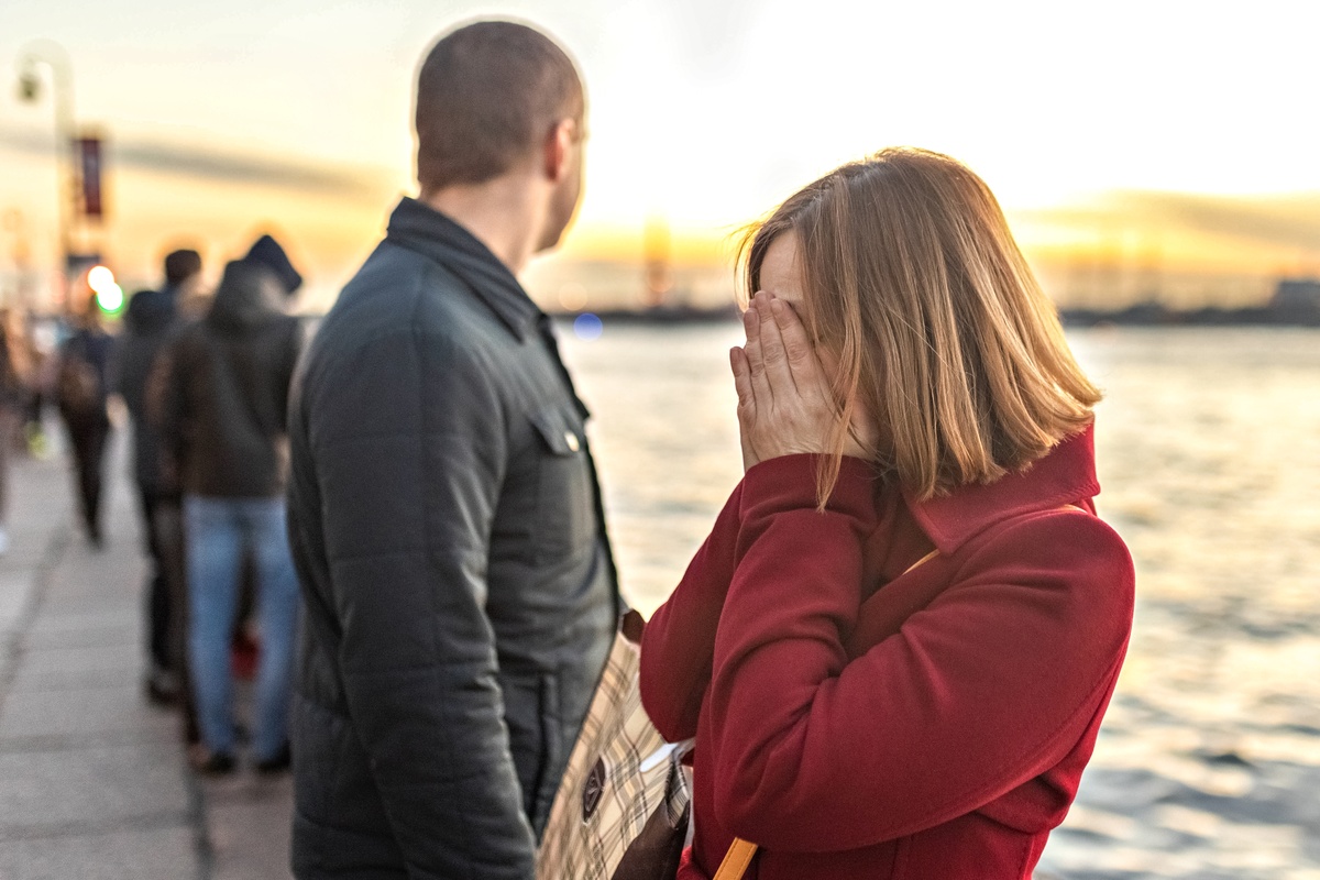 A woman holding her face in her hands.