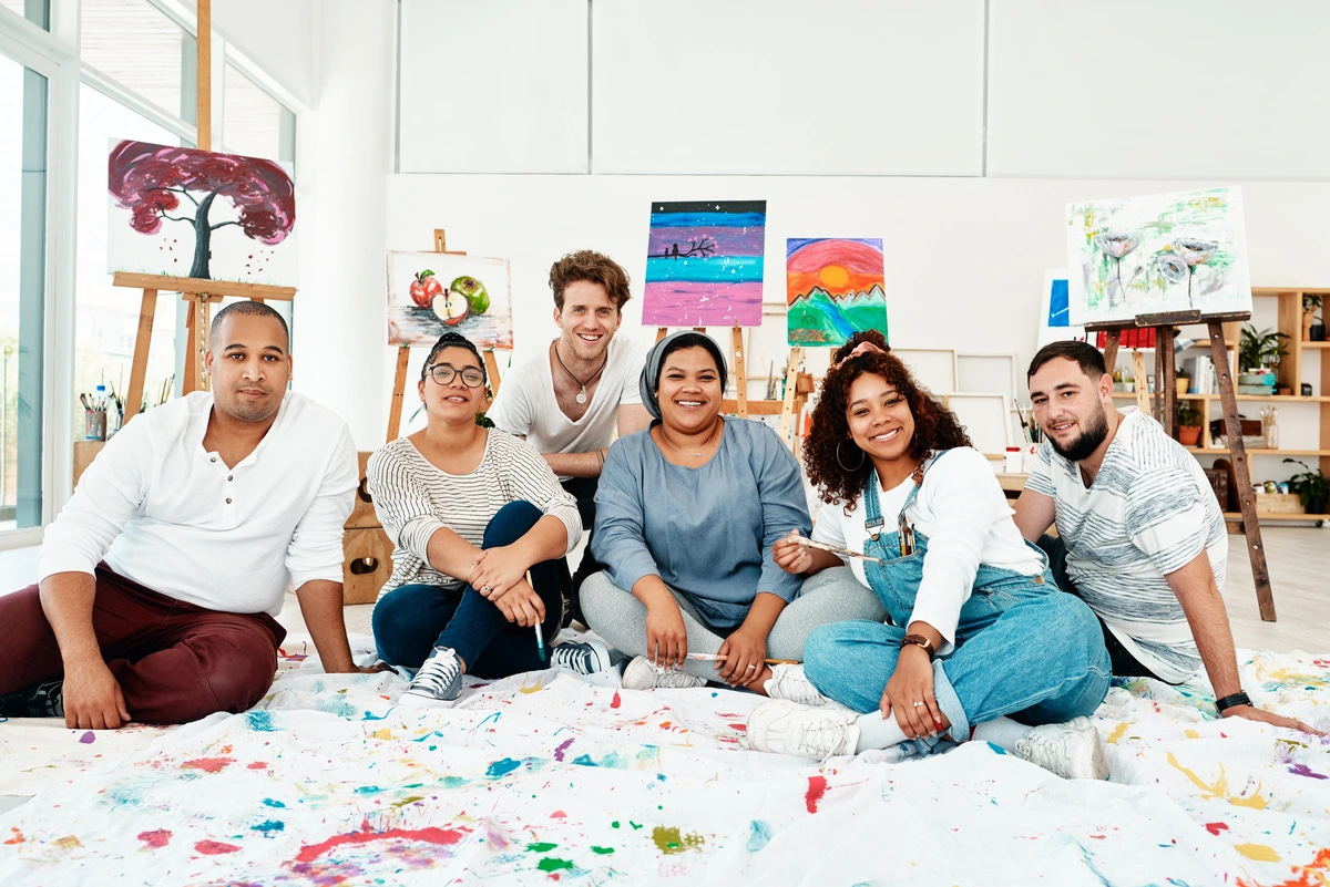 A group of people in recovery practicing art therapy, a form of experiential therapy.