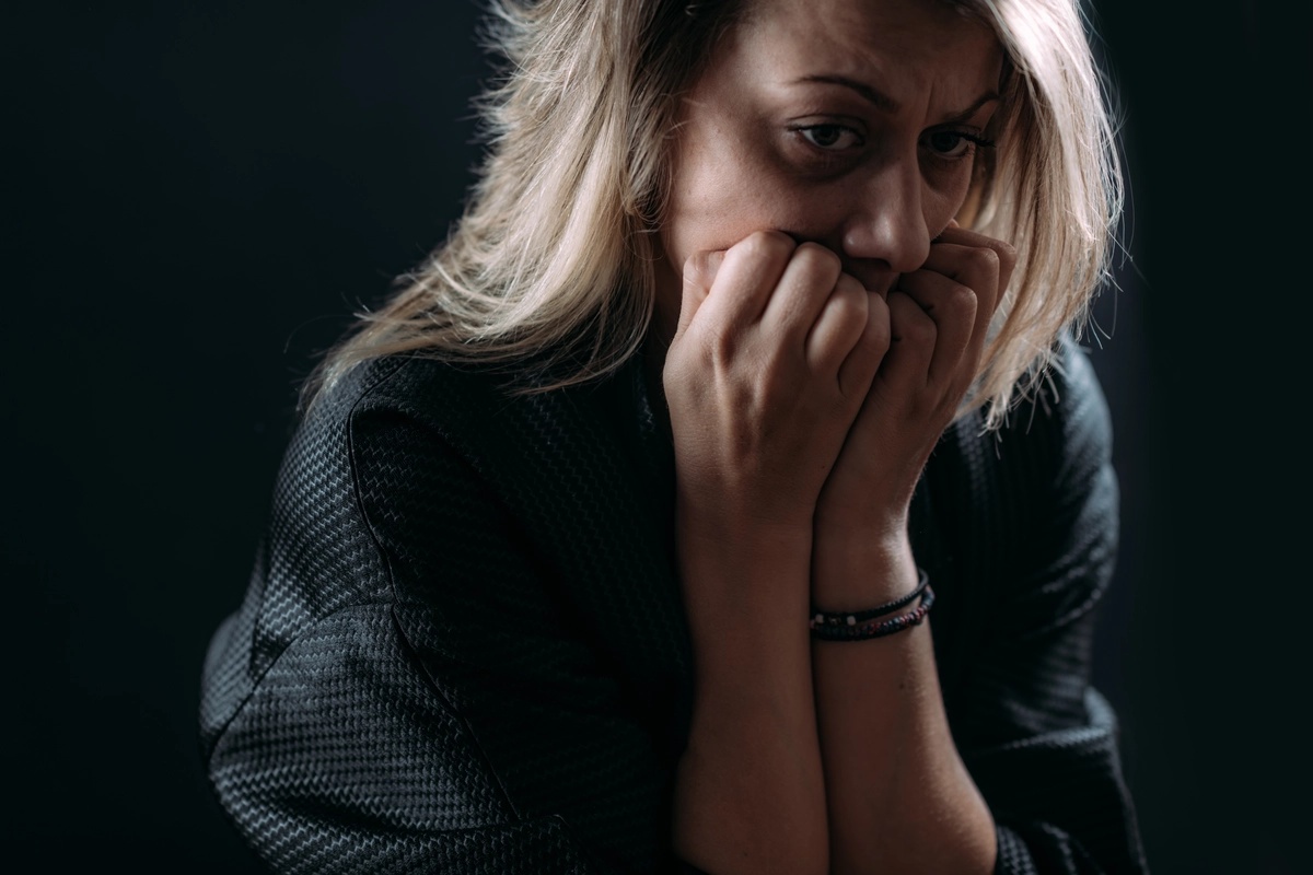 A woman biting her nails in an anxious state, possibly suffering a panic attack indicative of panic disorder.