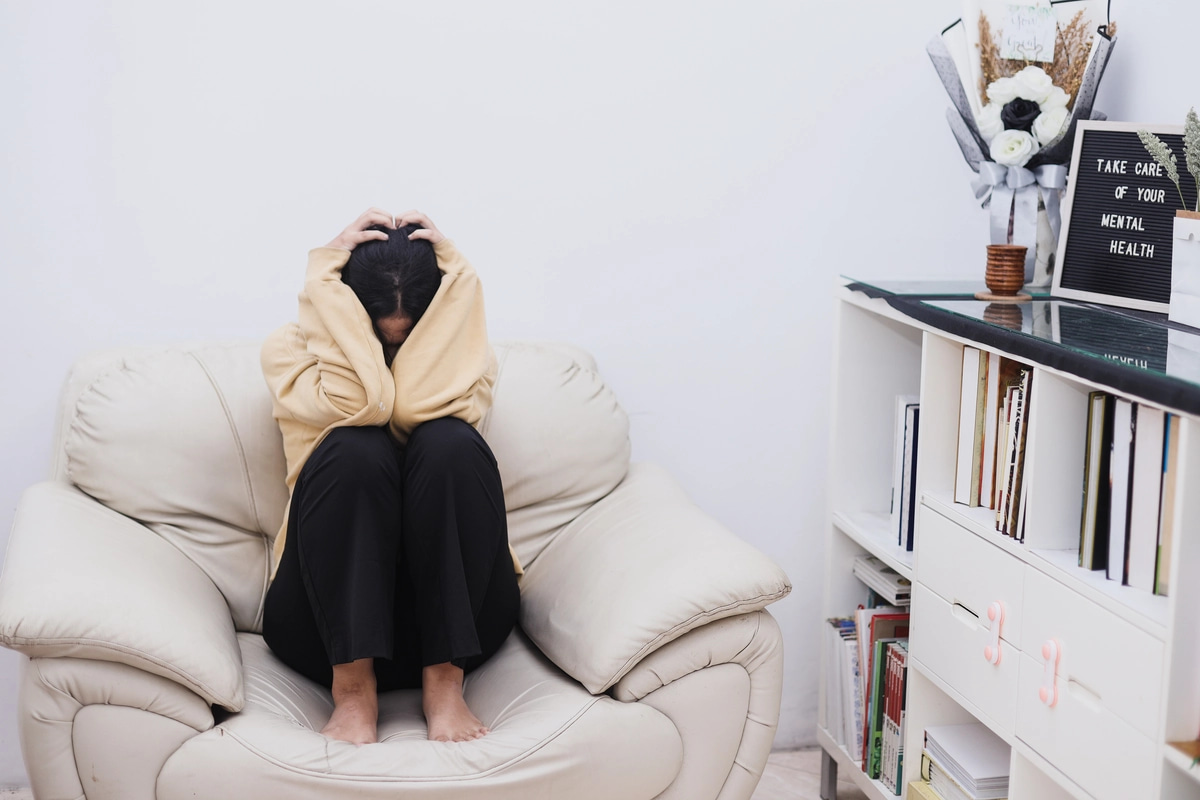 A woman sitting in isolation, struggling with depressive symptoms of bipolar disorder.