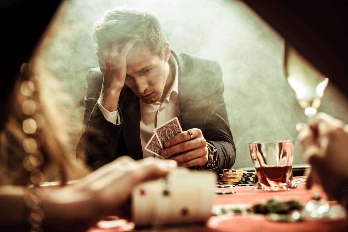 A man playing poker and struggling with a gambling addiction.