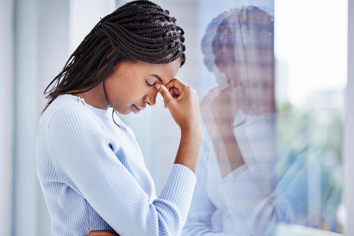 Woman with acute stress disorder at a window.