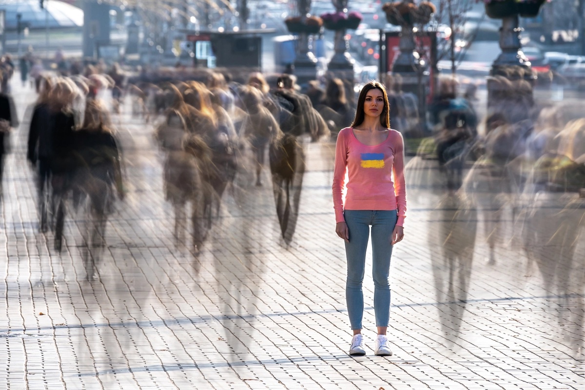 A woman in a crowd of blurry figures.