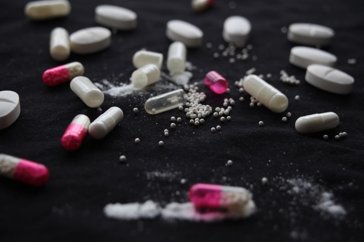 Numerous Xanax pills strewn about alongside other addictive prescription medications.