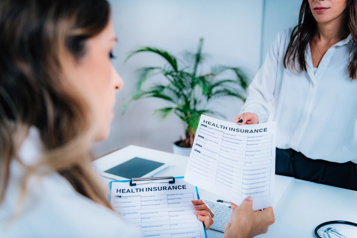 A doctor examines an insurance form for a patient considering inpatient rehab.