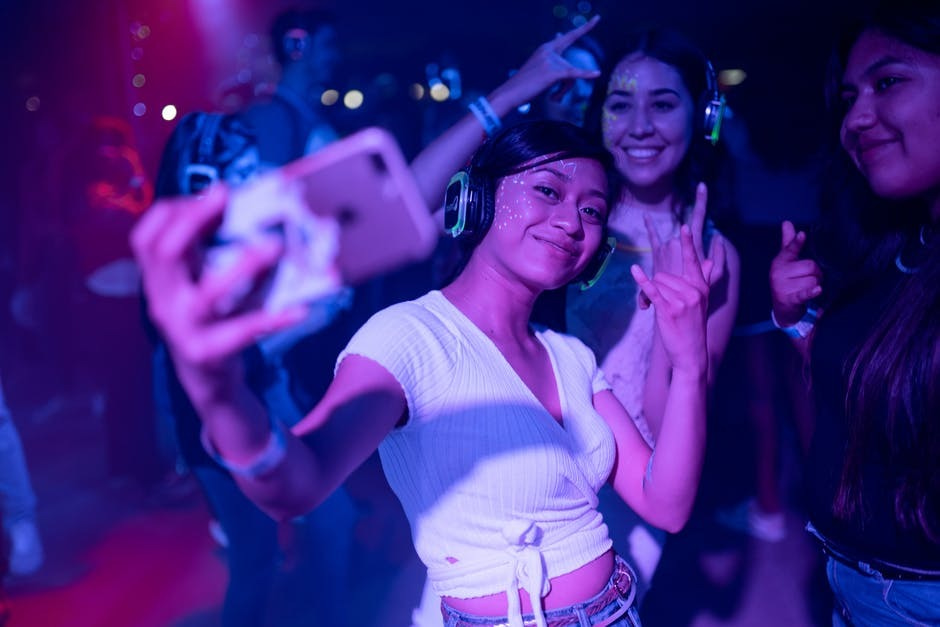 Photo of a woman taking a selfie at a dance club.