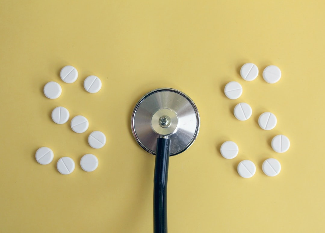 Photo of a doctor's stethoscope and pills arranged to read "SOS."