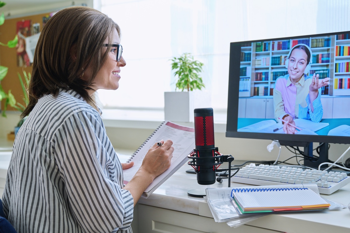 A woman in a video call with a member of her recovery alumni support group.