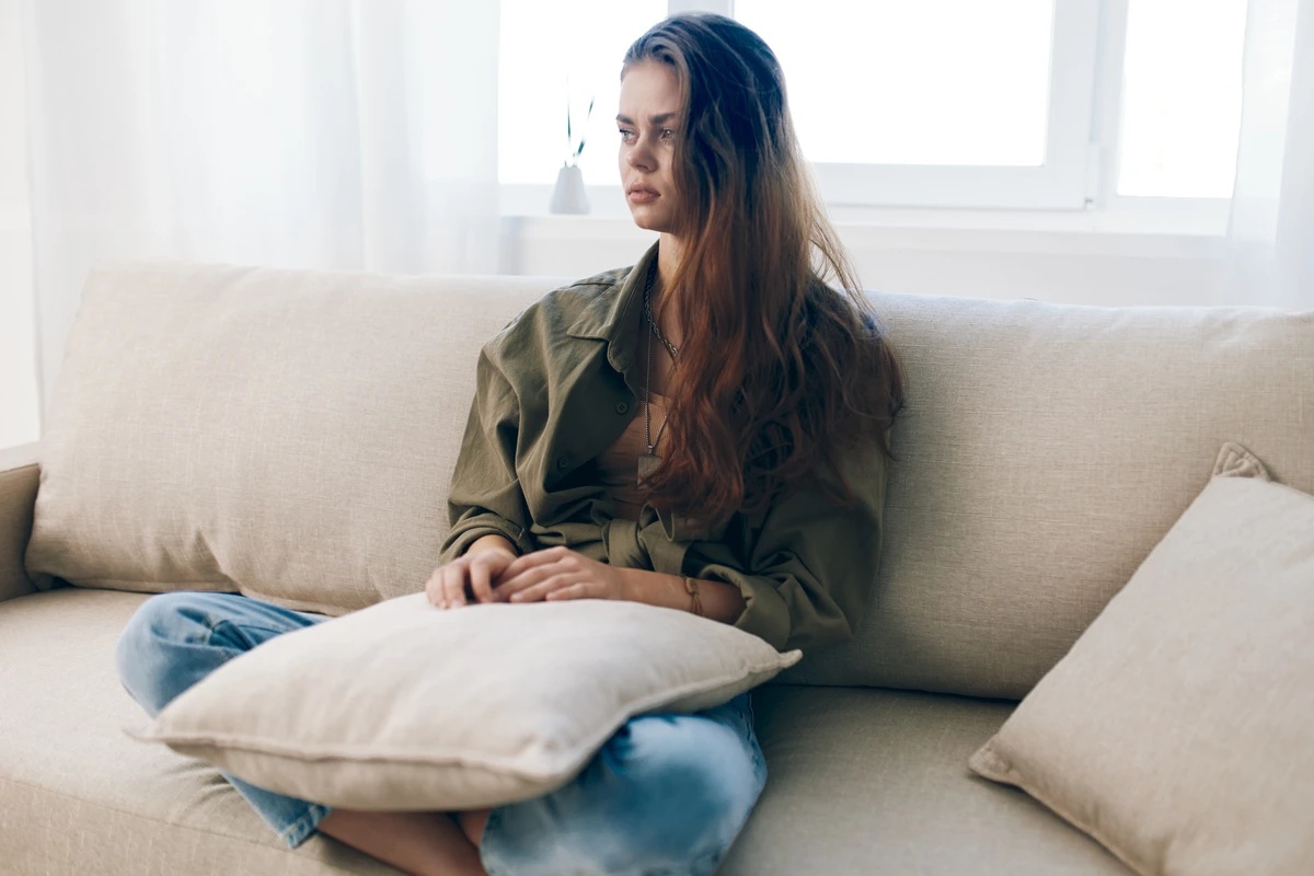 A woman sitting in silence, struggling with symptoms of depression.