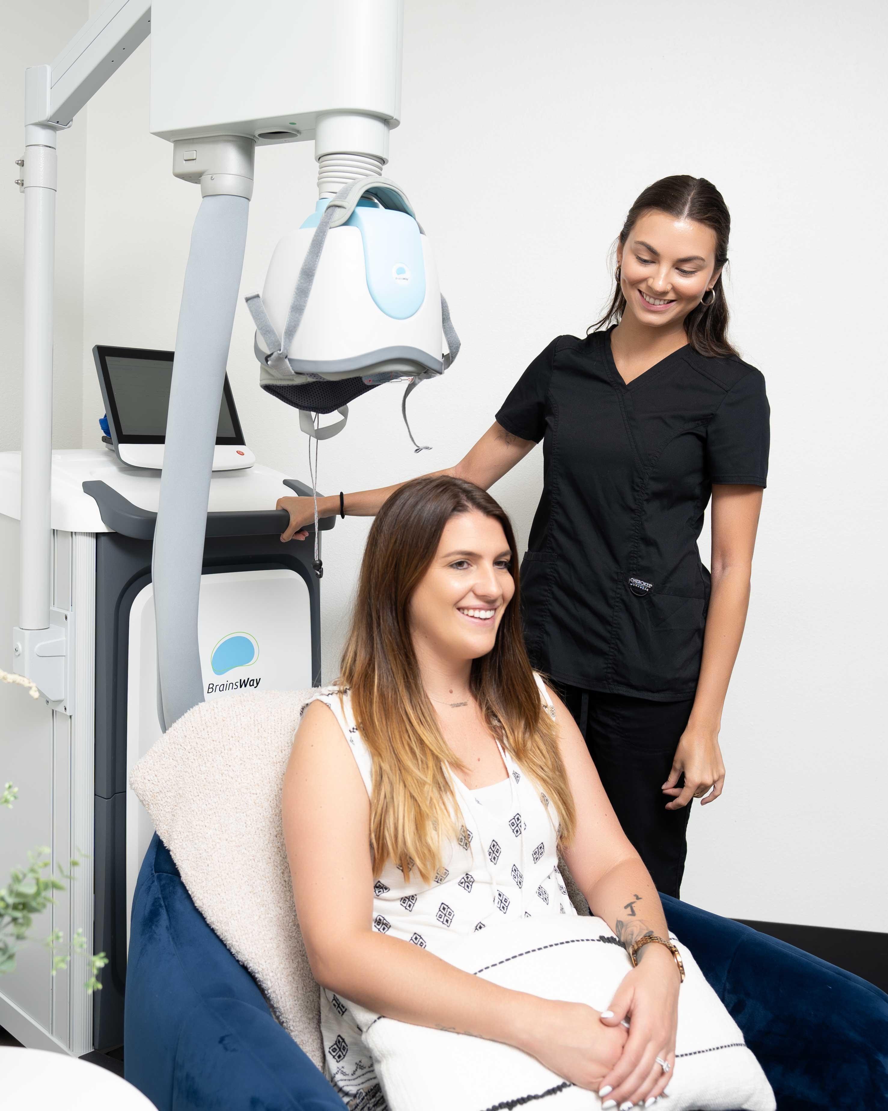 A woman smiling after completing her TMS session.