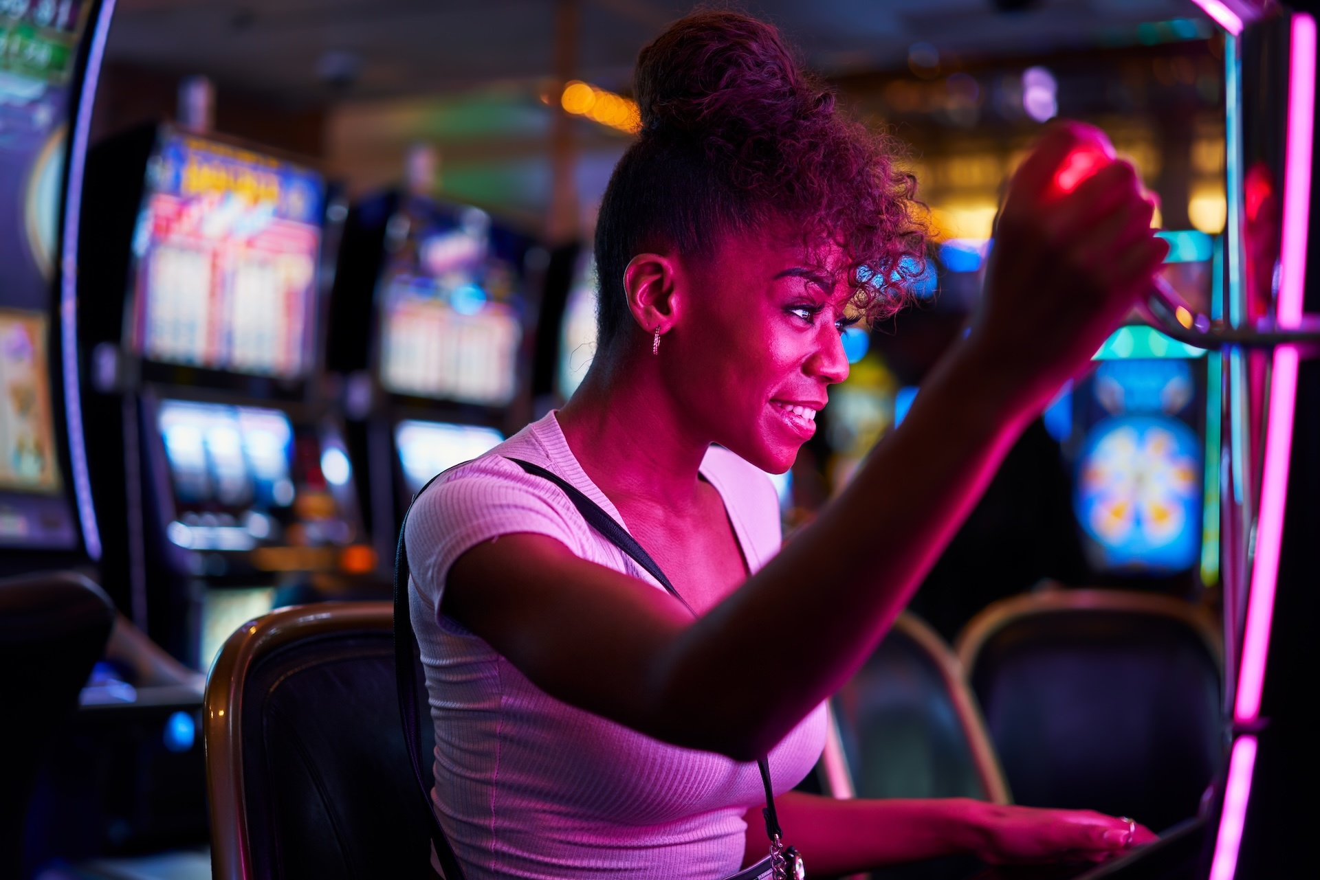 happy-woman-gambling-at-casino-playing-slot-machin-2023-11-27-05-00-50-utc