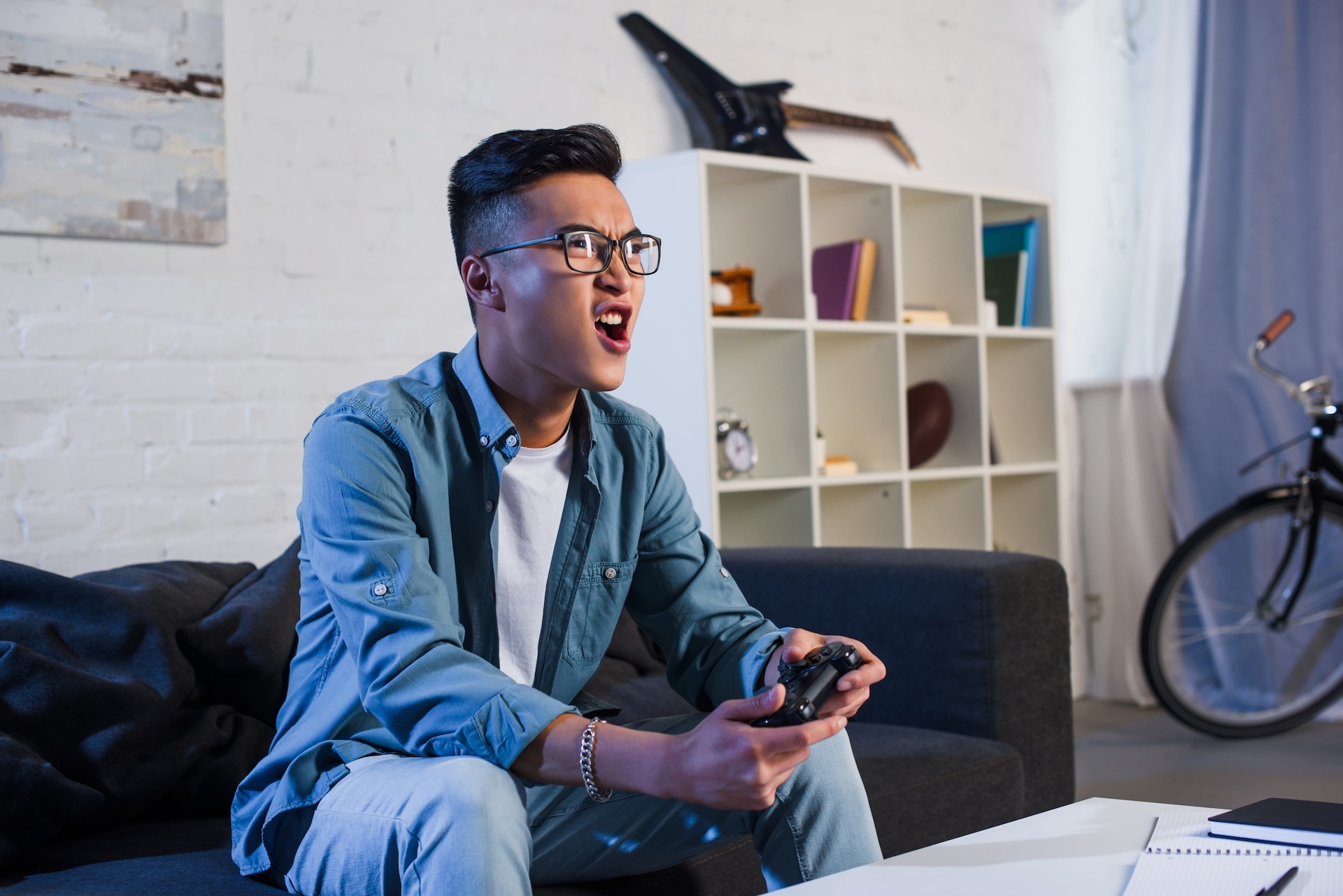 excited-young-asian-man-yelling-and-playing-video-2024-11-17-05-25-27-utc