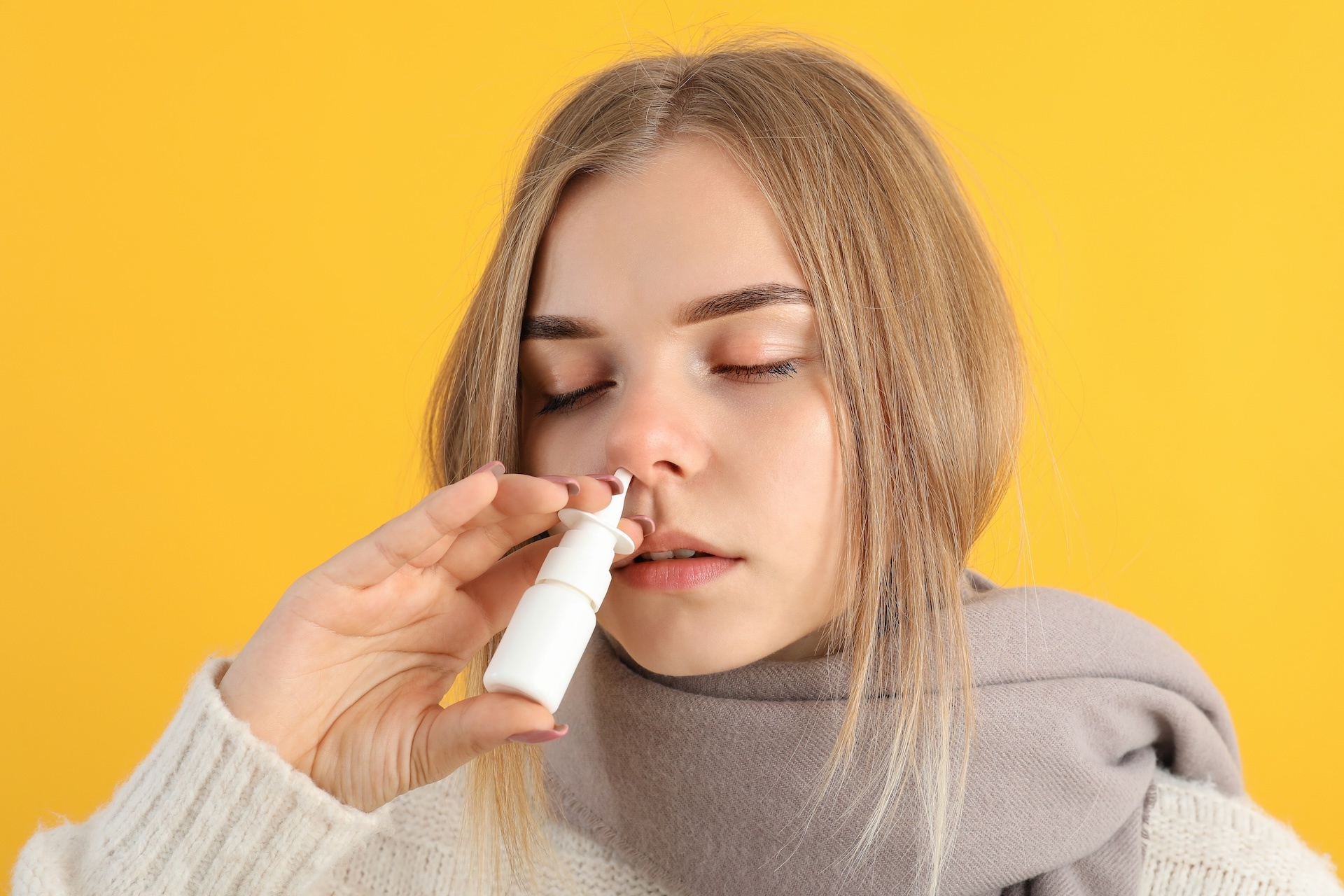 young-woman-with-nasal-drops-on-yellow-background-2023-11-27-05-05-25-utc