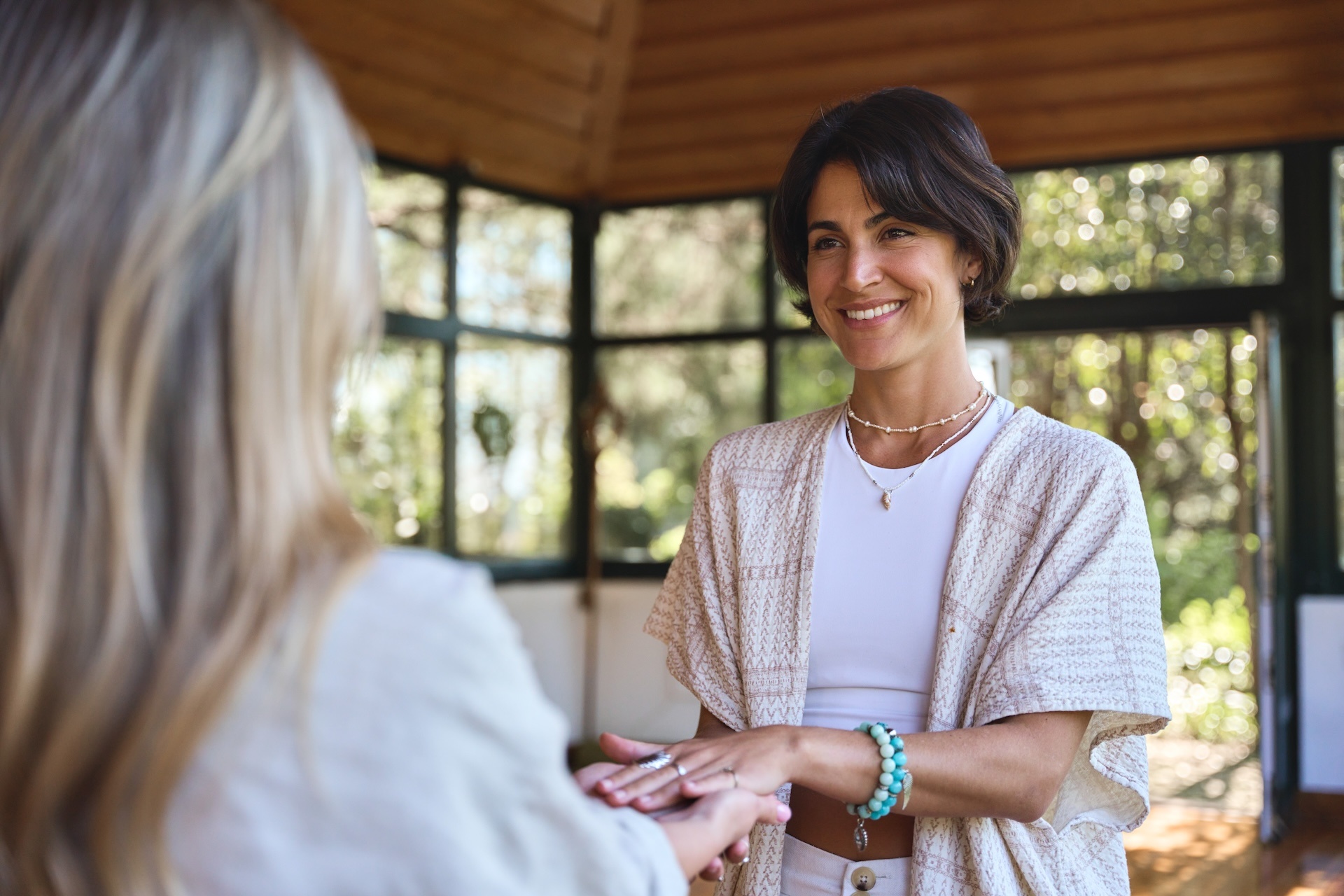 happy-female-holistic-teacher-holding-hands-of-wom-2025-02-11-15-57-27-utc