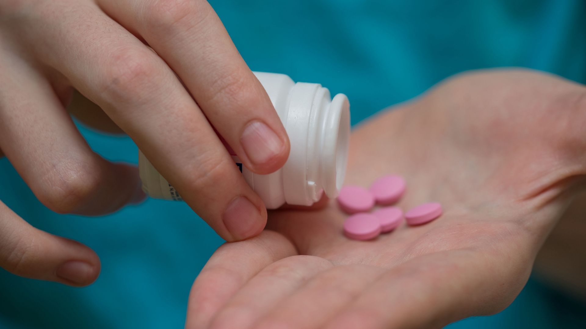 Benadryl addiction: pour over bottle of benadry in person’s hand. Benadryl addiction: pour over bottle of benadry in person’s hand.
