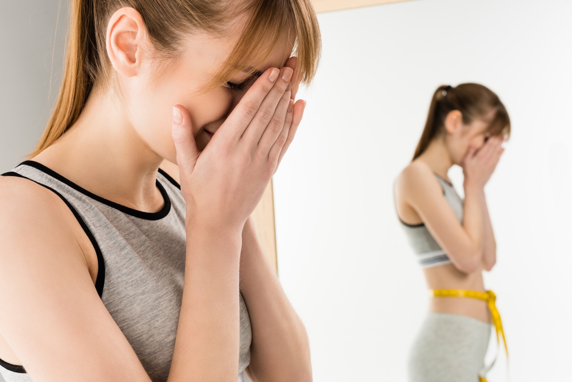 crying-woman-in-front-of-mirror-with-measuring-tap-2024-11-19-07-10-06-utc