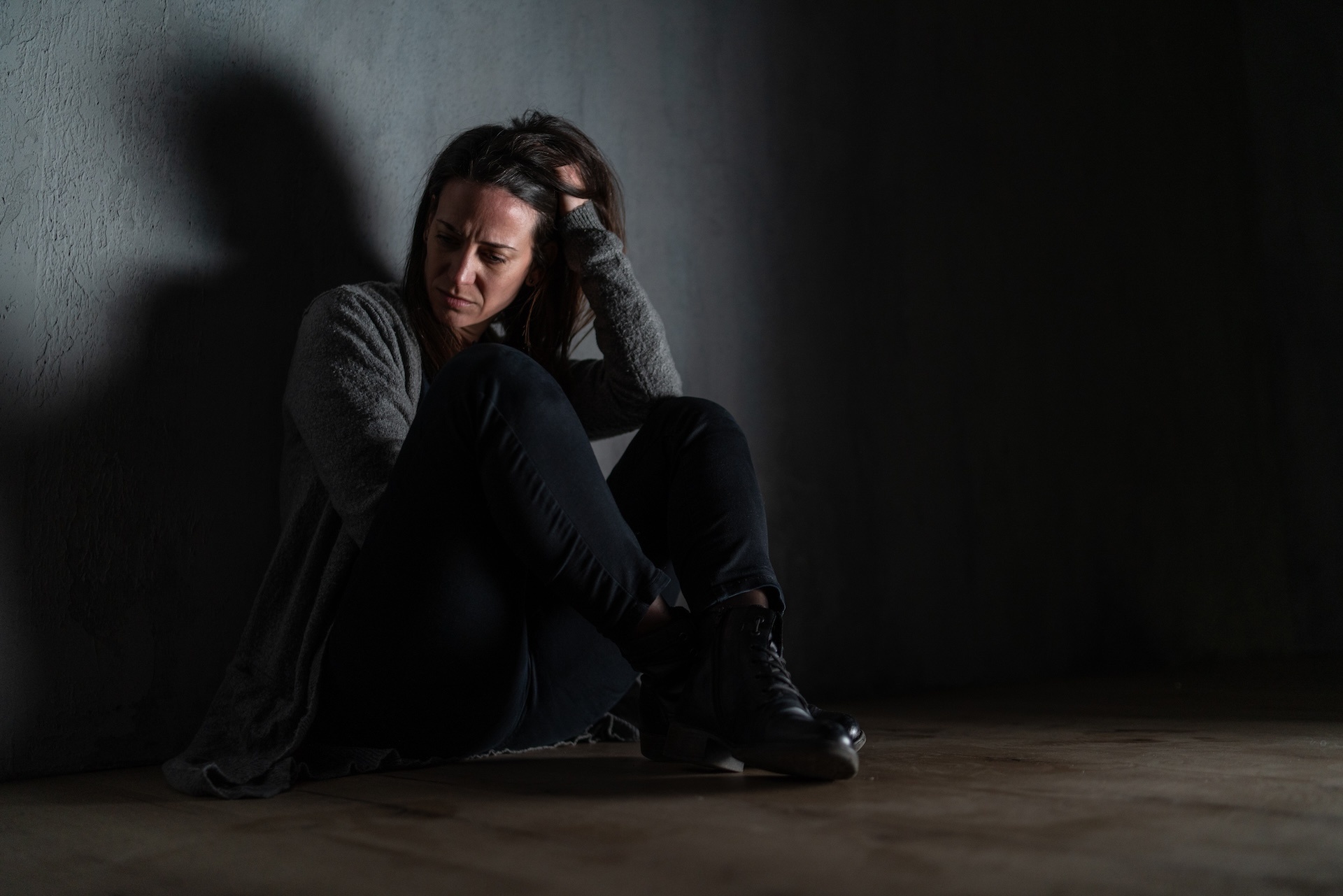 sad-mid-adult-woman-alone-in-darkness-sitting-an-2024-10-20-09-48-53-utc