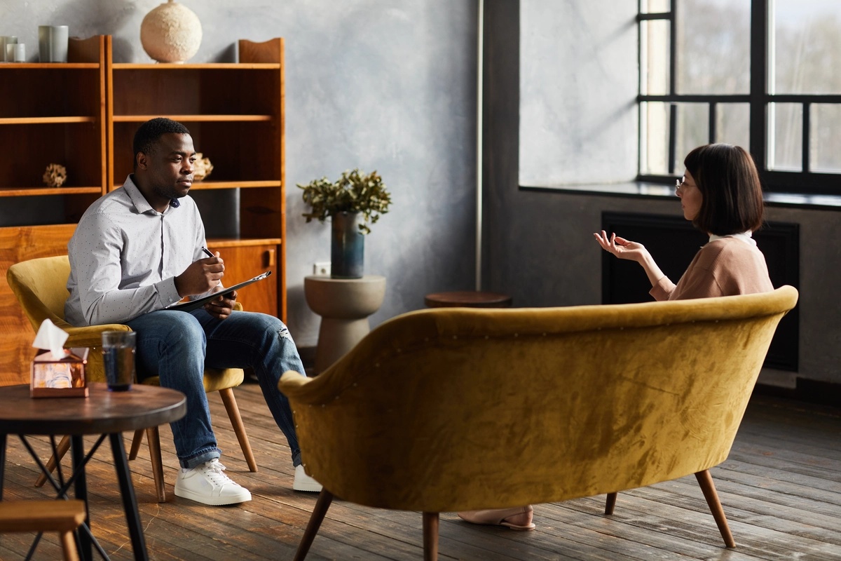 A woman in a CBT session with a therapist. A woman in a CBT session with a therapist.