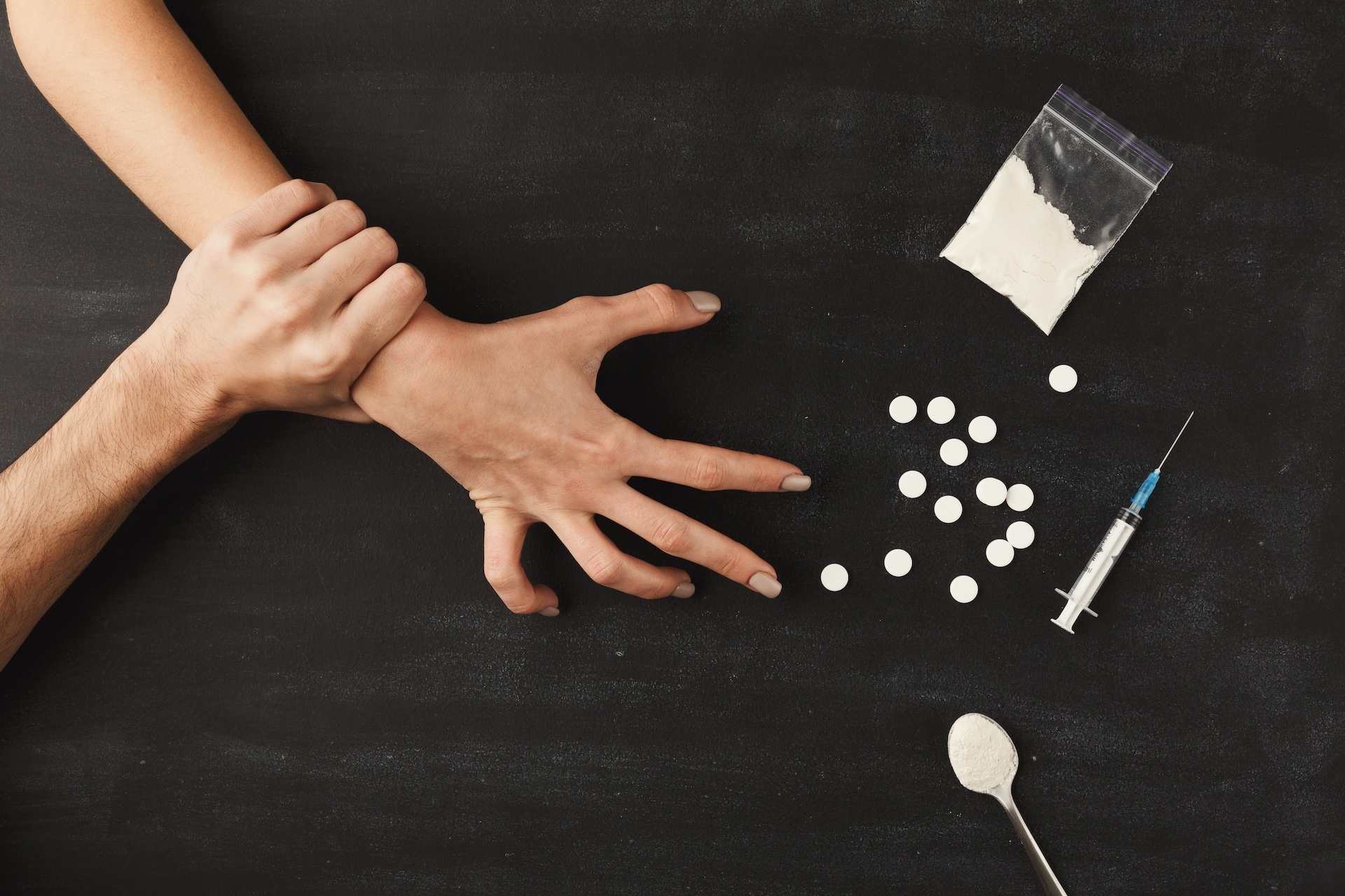 drug-addict-hands-on-dark-table-2023-11-27-05-18-19-utc