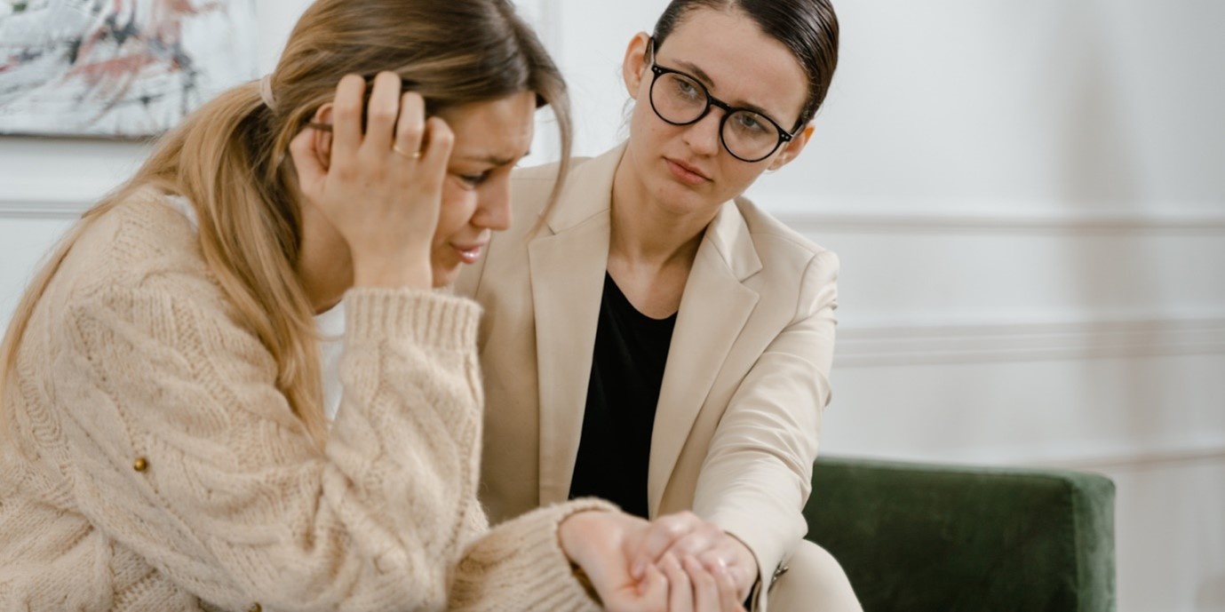 Depression & Drug Addiction: What You Need to Know A woman, presumably a therapist, comforts her patient on a couch.