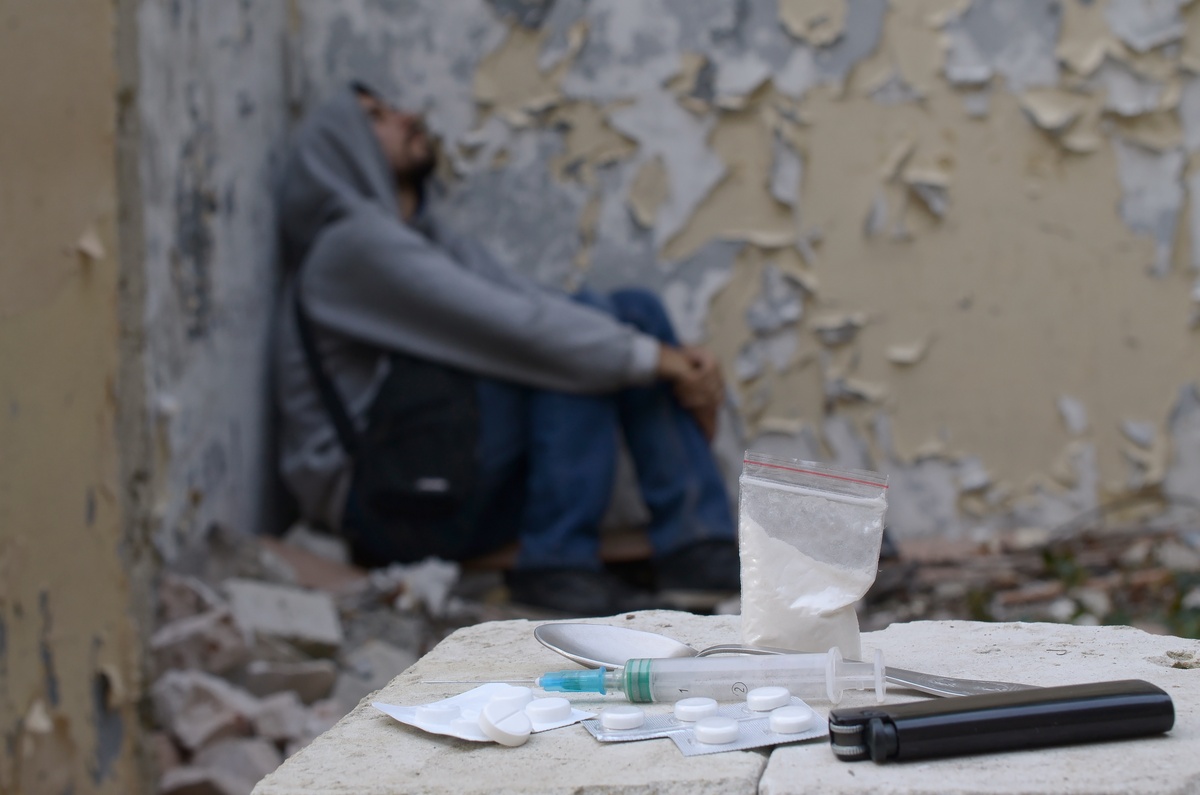A person sitting in a corner, struggling with symptoms of cocaine addiction. A person sitting in a corner, struggling with symptoms of cocaine addiction.